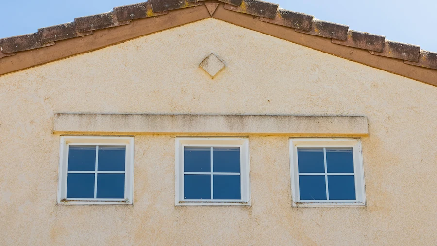 Light-colored stucco home facade with three windows, featured by Los Angeles Stucco Build & Repair.